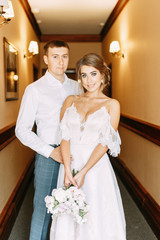  Stylish European wedding. Happy couple in the hotel hallway.