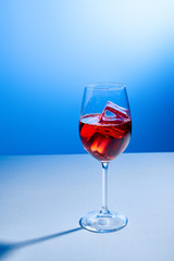 cocktail Aperol Spritz with ice cubes in glass on blue background