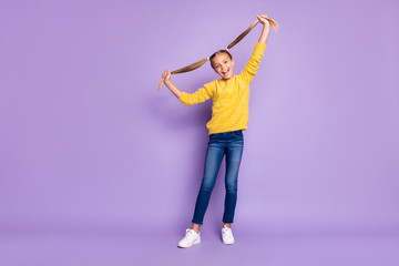 Full size photo of funny funky kid play hold pigtails have fun on spring weekends wear casual style clothing white sneakers isolated over violet color background