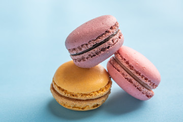 Macarons pattern on blue background. Colorful french desserts. Close up