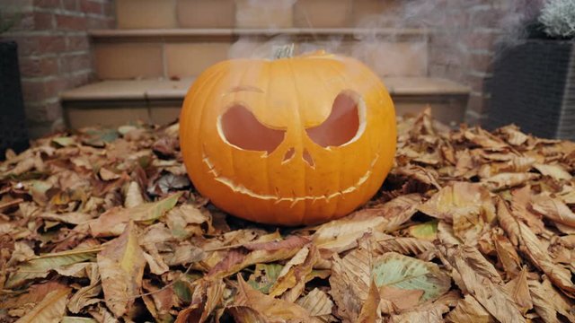 40% of realtime slow motion shot of halloween pumpkins with smoke in front of a house