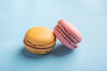 Macarons pattern on blue background. Colorful french desserts. Close up