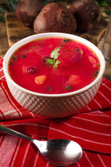 Red borscht soup in bowl.