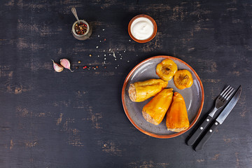 Colorful stuffed peppers with rice and minced meat on wooden background. Top view.