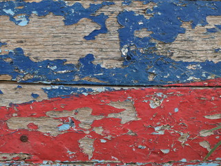 Peeling red and blue paint on wood