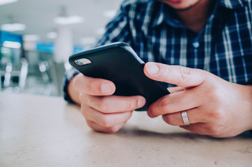 Men hands using smartphone at cafe. man typing an message.