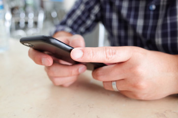 Men hands using smartphone at cafe. man typing an message.