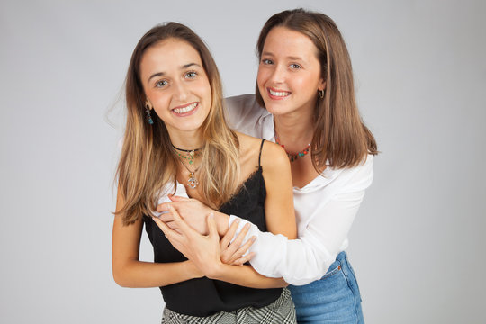 Dos chicas muy guapas abrazadas; amor fraternal, amigas cari&ntilde;osas guapas y sonrientes. Perfiles y siluetas de amor