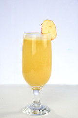 Cashew nuts isolated with glass of fruit juice on white background.