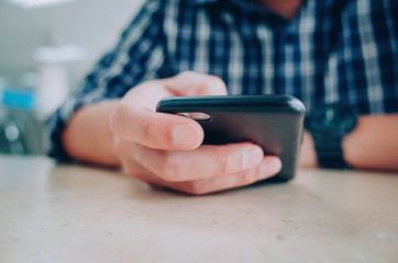 Men hands using smartphone at cafe. man typing an message.