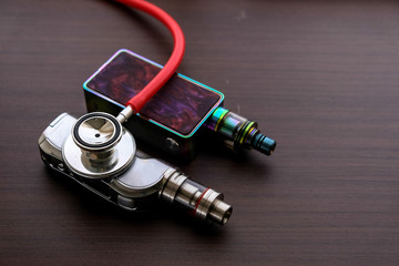 Conceptual image of uncertainty of health safety of e-cigarettes. Isolated close-up red stethoscope...