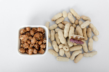 Peanuts and sugar-coated peanuts on a white background