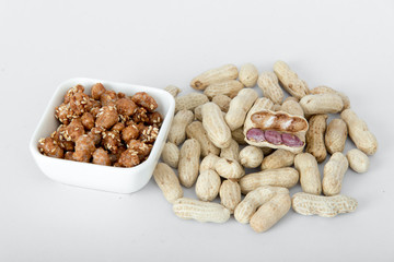 Peanuts and sugar-coated peanuts on a white background