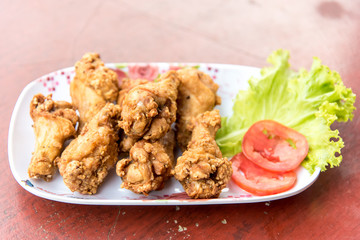 Fried chicken with vegetables and slide of tomatoes
