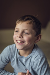 8 years old kid, european blond boy showing his mouth open, temporary baby milk teeth missing, childhood and dentistry or medical concept, tooth care, natural light shot at daytime
