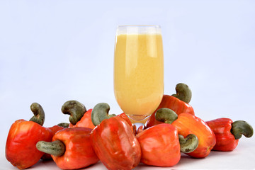 Cashew nuts isolated with glass of fruit juice on white background