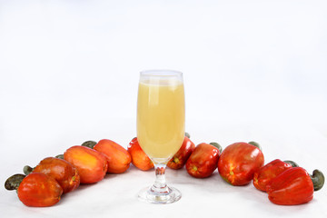 Cashew nuts isolated with glass of fruit juice on white background