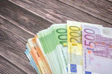 many euro banknotes on wooden background