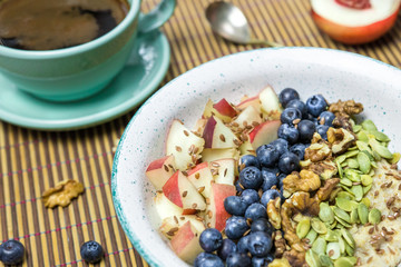 oatmeal breakfast with blueberries and peach and a cup of coffee