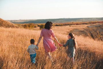 mother walking with children in grass