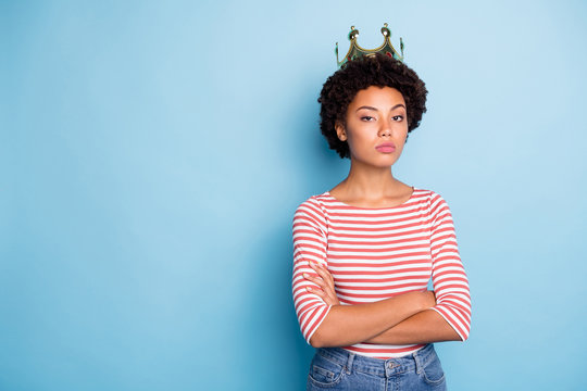 Photo of arrogant coronated woman feeling power after being crowned with arms crossed in jeans denim near empty space isolated pastel blue color background