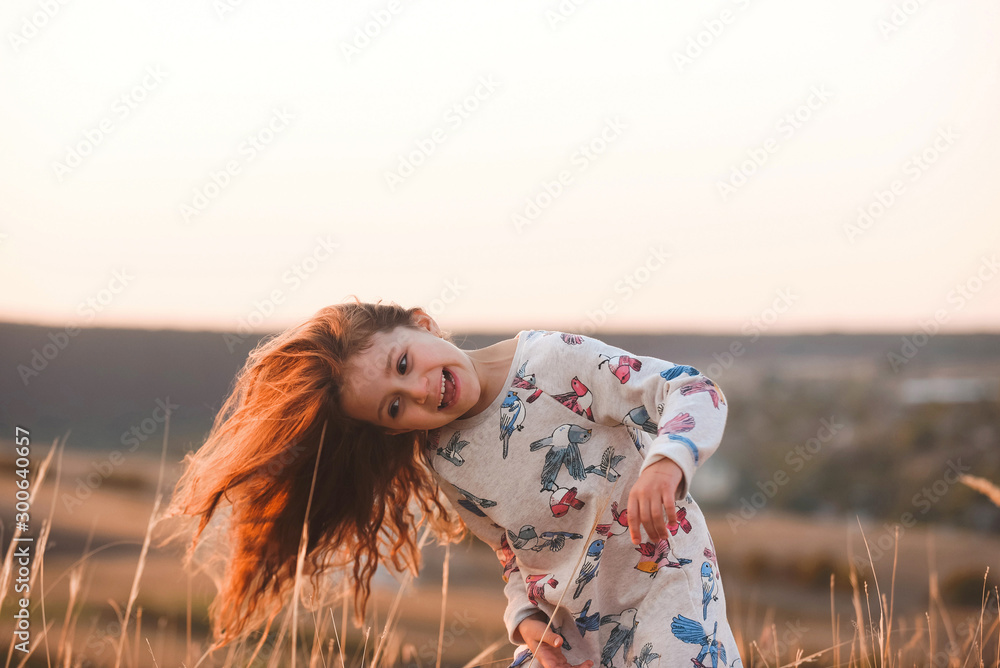 Wall mural girl playing with long hair in field