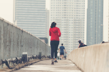 Young women runner on the street be running for exercise on city road; sport, people, exercising and lifestyle concept