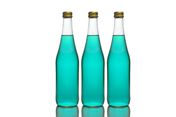 Three large glass bottles with light blue liquid stand on a mirror surface on a white background in the middle.