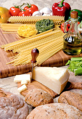 Cheese platter with different cheese, bread, pasta and vegetable.