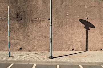 Isolated light pole in the sidewalk near parking rows on a paved road (Madeira, Portugal, Europe)