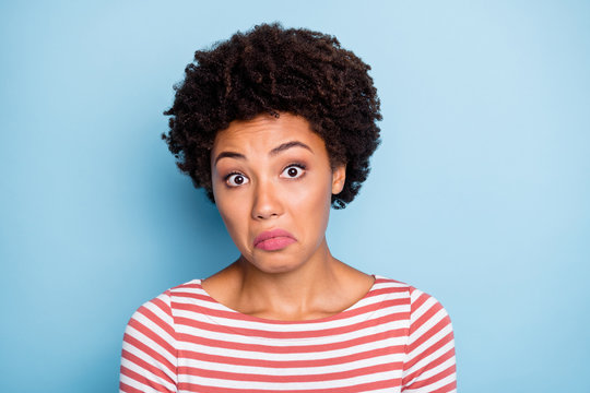 Close up portrait of puzzled wondered ignorant girl expressing emotions of unknown on her face showing unawareness isolated over blue pastel color background