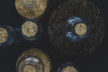 Glass bottles with cork lids on black background