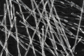 Extreme close up, top down view of polypropylene crimped macro fibers for concrete reinforcement on...