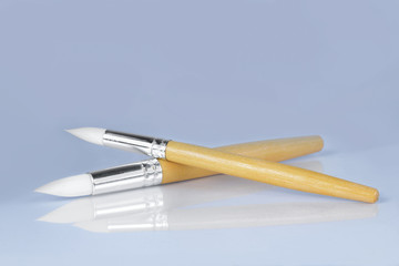 Paint brushes on gray background, front view