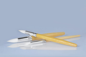 Paint brushes on gray background, front view