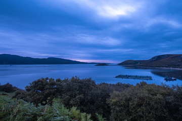 Obraz premium Salmon farms amidst gorgeous landscapes in the far north of the Scottish highlands along the iconic NC500 coastal route