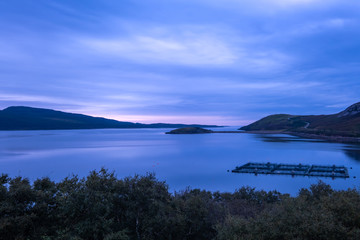 Salmon farms amidst gorgeous landscapes in the far north of the Scottish highlands along the iconic NC500 coastal route