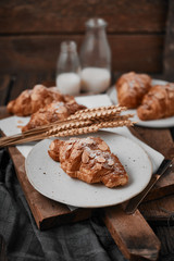 Almond croissant with custard filling on wood background.