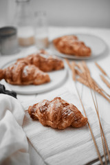 Almond croissant with custard filling on wood background.
