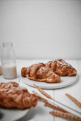 Almond croissant with custard filling on wood background.