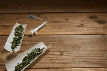 drugs concept. syringes and smoking weed on a wooden surface with space for text.