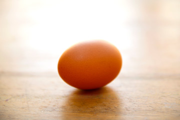 Raw single brown chicken egg isolated on a wood table, cooking healthy food