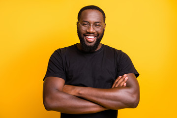 Photo of cheerful toothy beaming guy with arms crossed looking into camera standing confidently...