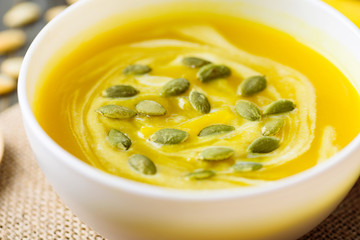 Pumpkin soup with pumpkin seed in a bowl, close up