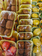 A lot of fruit Packed in plastic bags on the shop window.