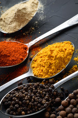 Various spices spoons on stone table.On dark concrete background.Herbs and spices on wooden table.  Top view with space for your text
