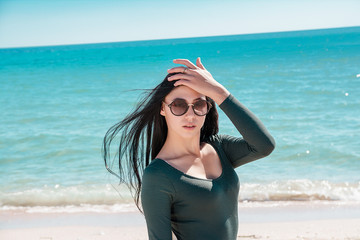 Portrait of girl by sea. Woman in bodysuit with long sleeves.