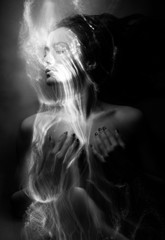 Conceptual monochrome black and white avant-garde portrait of a beautiful young girl covered with...