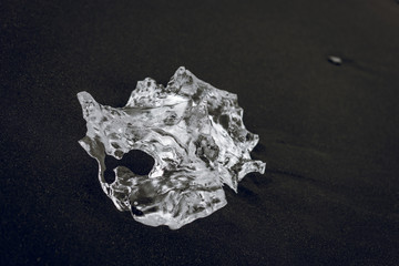 Ice chunk on a black beach in Iceland. Lava sand, beach, black, global, arctic, ice, chunk, melting, global warming, climate change concepts.