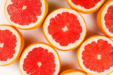 Naklejka na ściany i meble Grapefruit red juicy slices background. top view